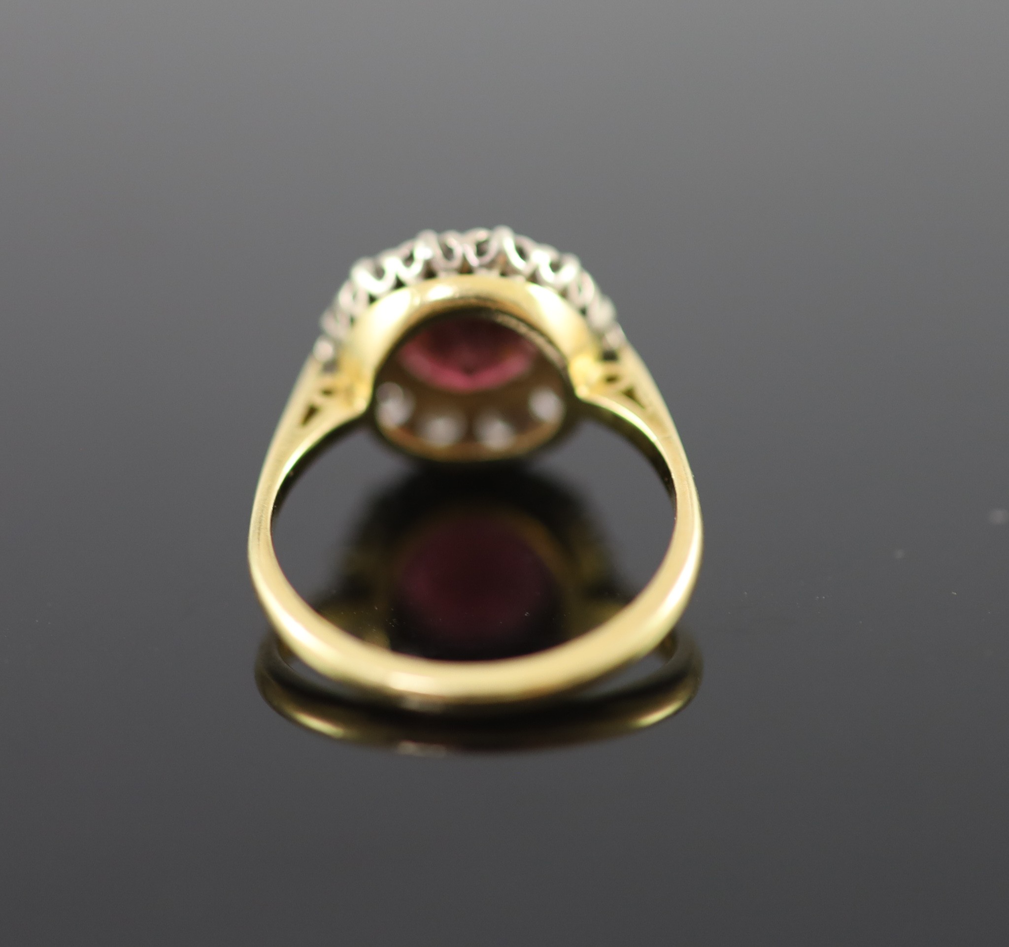 A modern 18ct gold, deep pink tourmaline and diamond set oval cluster ring